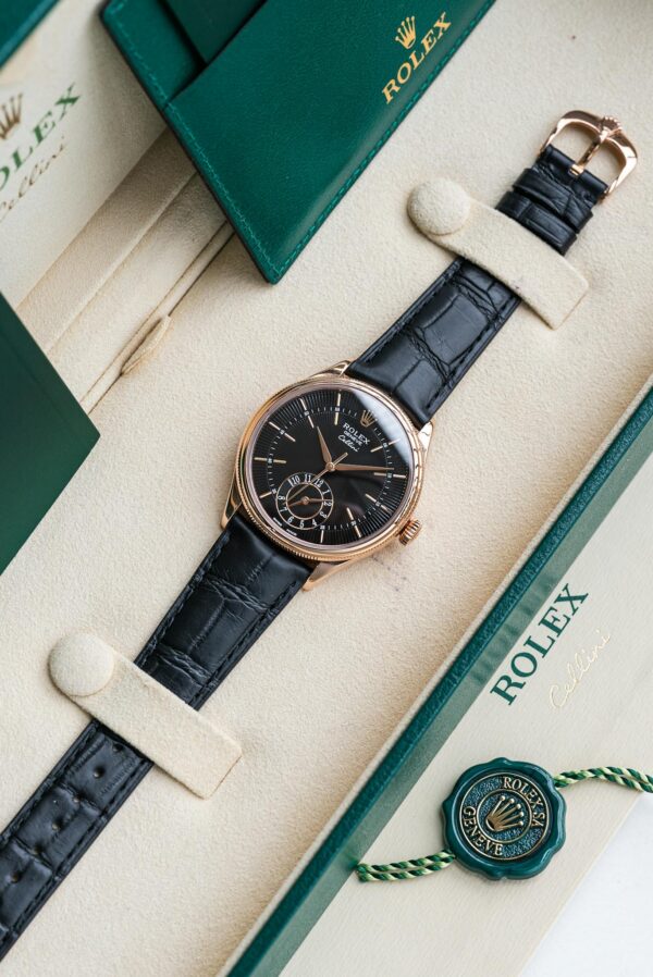 Elegant Rolex watch displayed in a luxury box with green accents and leather strap.