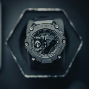 Modern G-Shock watch in a studio setup with black background, top view angle.