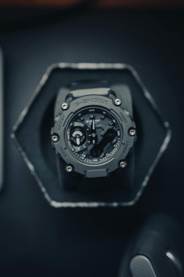 Modern G-Shock watch in a studio setup with black background, top view angle.